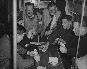 The table in the tiny messdeck of a Fairmile is used for a friendly game of cards. Left to right are, Ordinary Seaman M. Hines of Vancouver, Telegraphist T. Goldie, Cape Breton, Leading Seaman H. Doucet, Nova-Scotia, Ordinary Seaman, A. Nicholson of Vancouver, Ordinary Seaman W.Parker of Regina and Signalman R. Gifford of Winsor, Ont. Royal Canadian Navy collection ( R-778)
